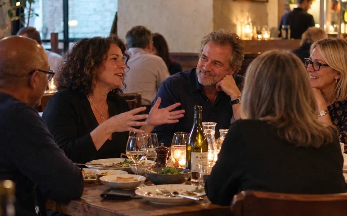 A matched group talking over dinner at a candlelit restaurant table
